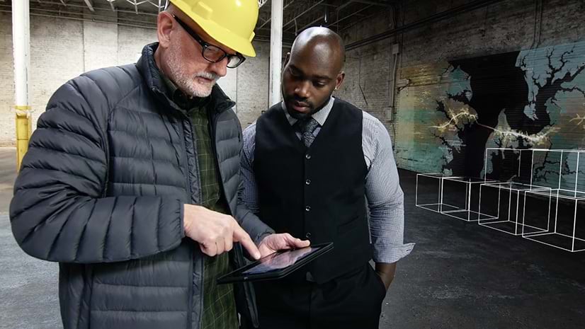 Two people looking at a tablet together in a warehouse