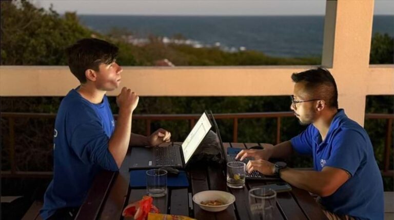 Two men working on laptops