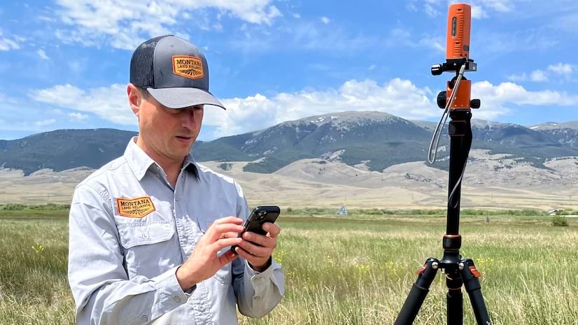 A mobile worker in the field typing data on a mobile phone