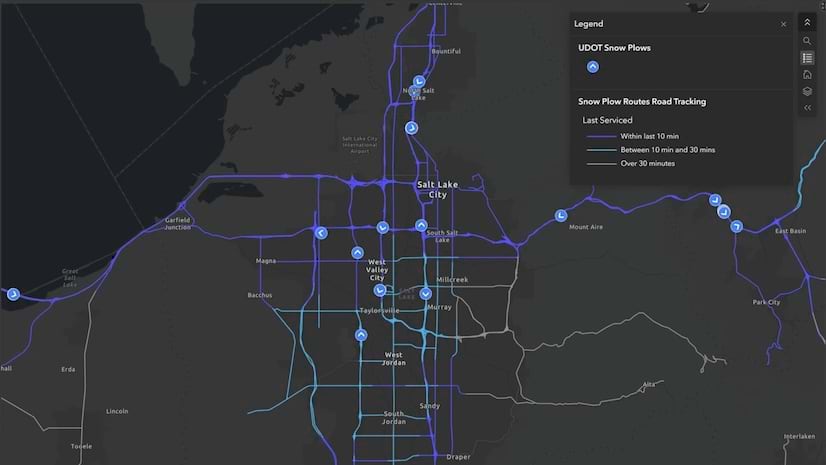A live snowplow tracking dashboard with routes in purple, scattered blue data points, and city names
