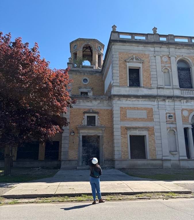 A woman standing in front of a historical building during the day