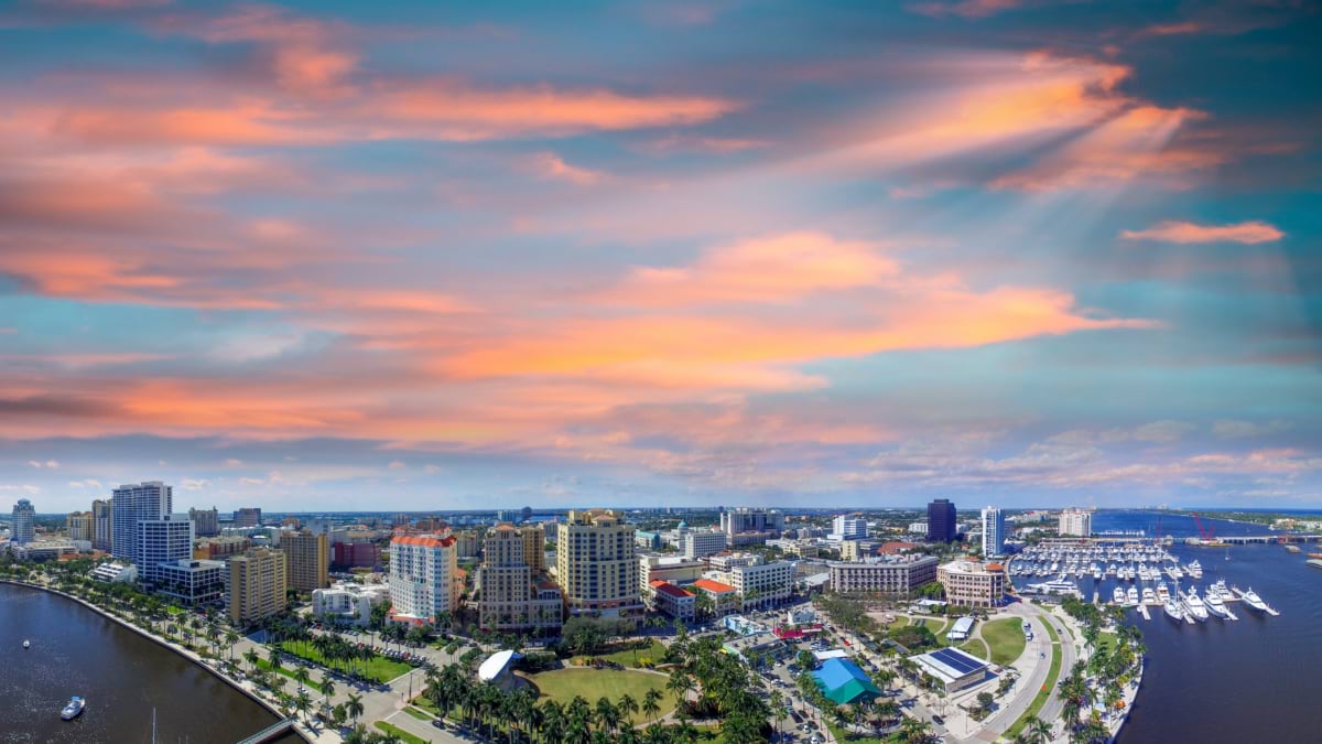 Aerial view of downtown West Palm Beach skyline and marina at sunset.