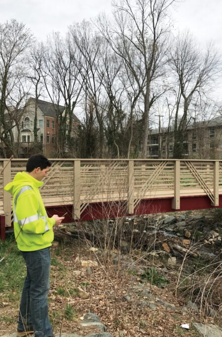 A city employee uses Collector for ArcGIS on a mobile device to obtain information about a bridge in Falls Church. (Photo courtesy of Andrew Peters.)