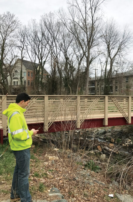 A city employee uses Collector for ArcGIS on a mobile device to obtain information about a bridge in Falls Church. (Photo courtesy of Andrew Peters.) A city employee uses Collector for ArcGIS on a mobile device to obtain information about a bridge in Falls Church. (Photo courtesy of Andrew Peters.)