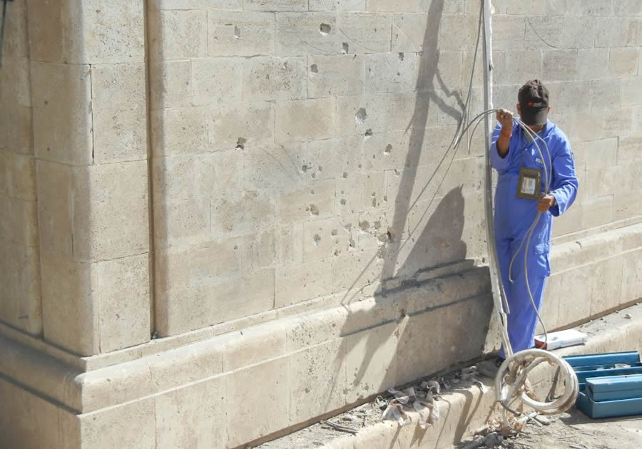 A worker starts to repair a building damaged by a rocket in the Green Zone in Baghdad, Iraq. Berry served in both Afghanistan and Iraq.