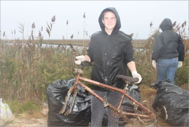 A volunteer picks up debris near a waterway in New Jersey.