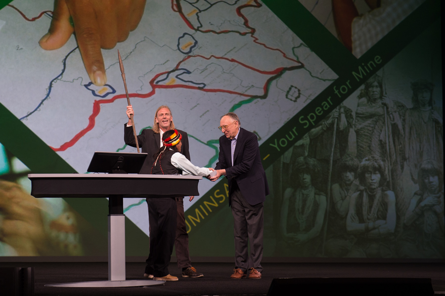 Resl raises the ceremonial spear in happiness as Ankuash and Dangermond shake hands in friendship.