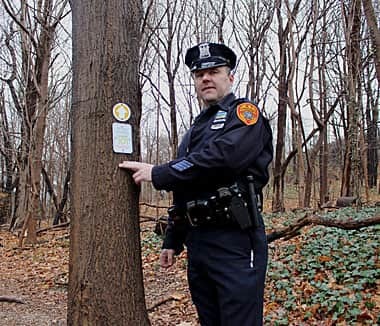 Officer James Garside of the Suffolk County Police Department spearheaded the drive to install the trail markers in Cold Spring Harbor State Park. Photo by Janee Law © Long Islander News. Used with permission.