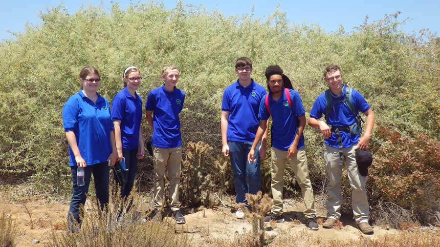 Sarah Martin of New York state; Mary Katherine DeWane, Austin Ramsey, and Edward DeWane of Tennessee; Dylan Dodson of North Carolina; and Wyatt Luther of Tennessee stand in the Tijuana Slough National Wildlife Refuge, ready to map invasive plants.