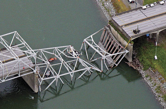 Part of the Skagit River Bridge collapsed when a tall semi-truck, driving in the wrong lane, struck its trusses. Part of the Skagit River Bridge collapsed when a tall semi-truck, driving in the wrong lane, struck its trusses.