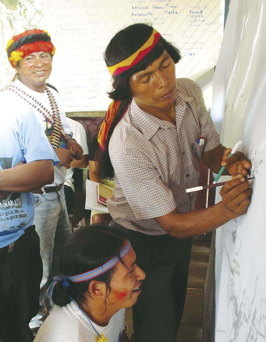Leaders of the Achuar use maps to draw their land. (Photo courtesy of AmazonGISnet.)