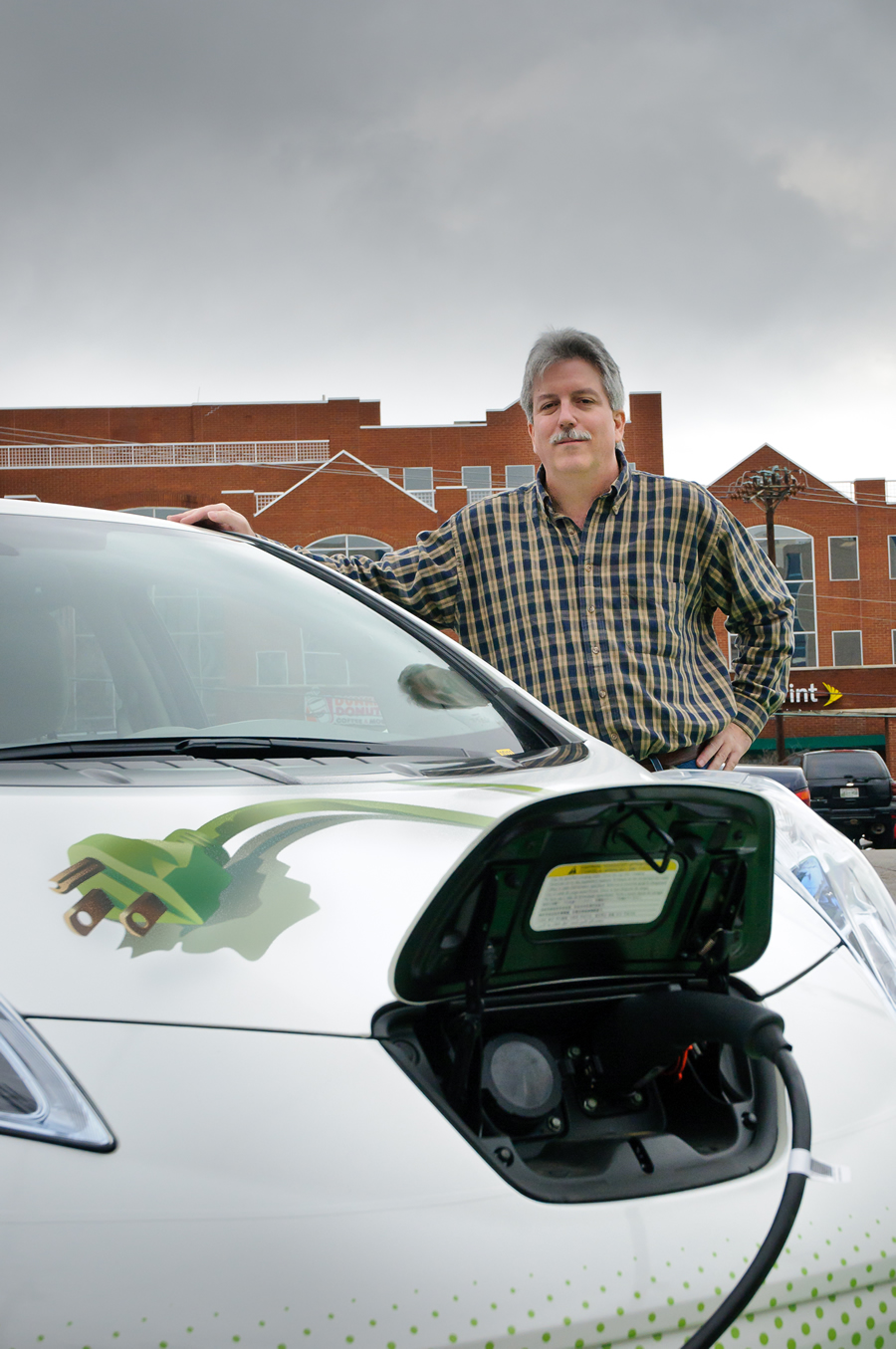 Brown charges one of the NES electric vehicles in a parking lot near Vanderbilt University in Nashville. Credit: Joe Weaver Photography. Brown charges one of the NES electric vehicles in a parking lot near Vanderbilt University in Nashville. Credit: Joe Weaver Photography.