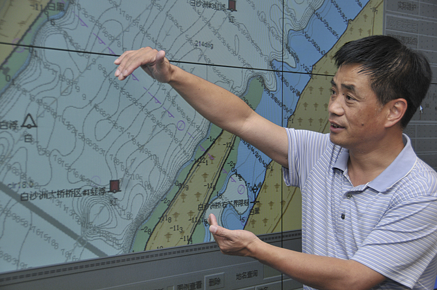 Staff member for the Changjiang Waterway Bureau reviewing nautical charts.