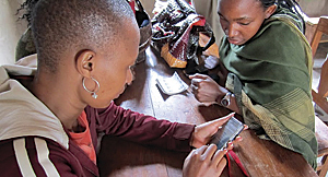 A health care worker collects data using a smartphone.