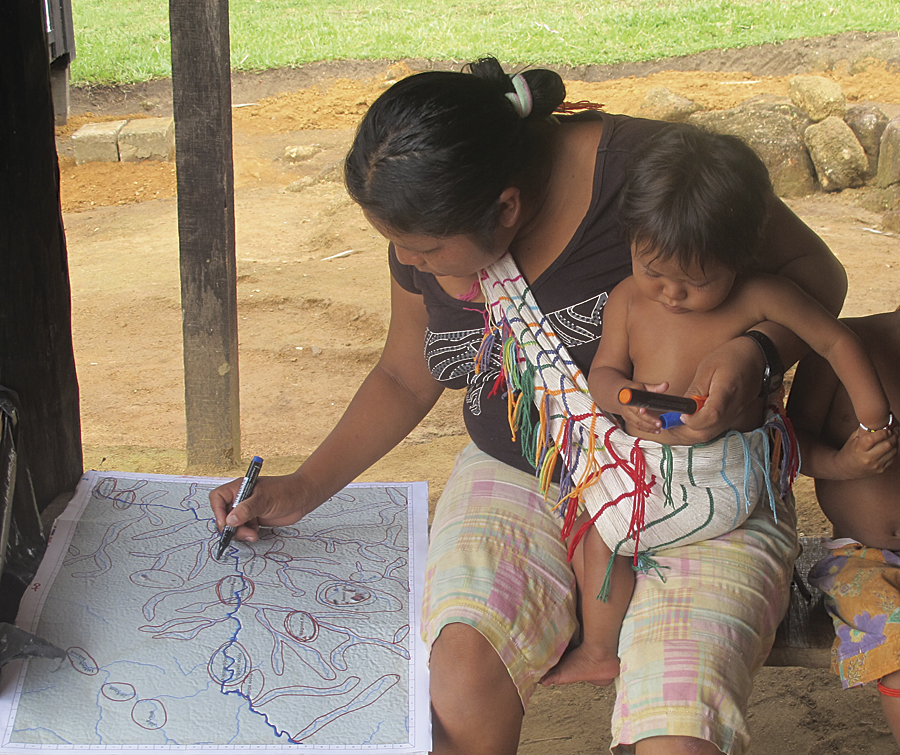 A village woman drawing polygons on an elevation map.