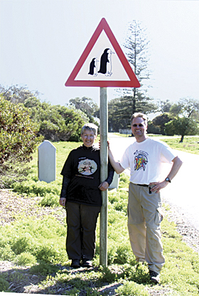 Kathryn Scott and Brian Hall, GIS analysts posed with their Esri T-shirts at a penguin crossing on Robben Island Kathryn Scott and Brian Hall, GIS analysts posed with their Esri T-shirts at a penguin crossing on Robben Island