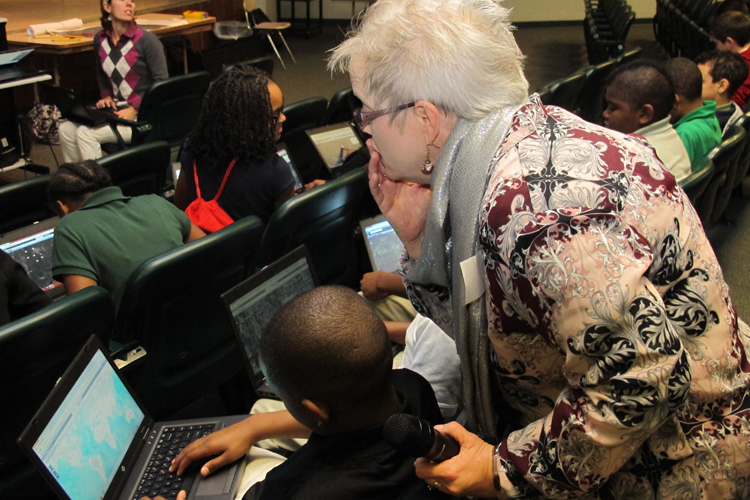 Beverly Richey, a geographer and GIS specialist from the US Army Corps of Engineers Huntsville Center, helps a sixth grader at Ed White Middle School work with an online map.