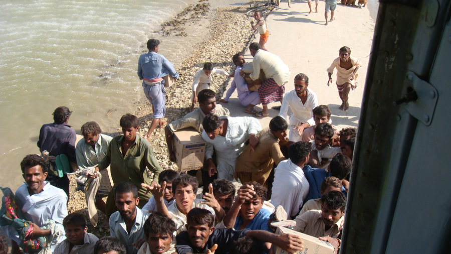 Village residents carry away boxes of energy biscuits.