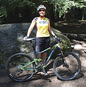 Gretchen Brown, CAD/GIS specialist poses an Esri cycling jersey shirt