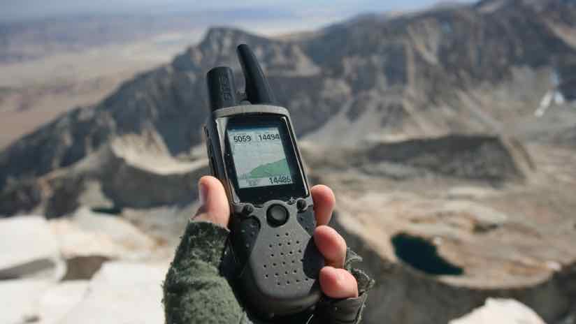 handheld GPS receiver in a mountain landscape