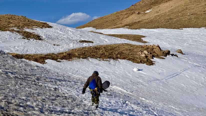 snowboarder walking with bare patches