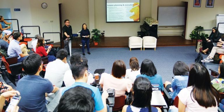 Two teachers giving a presentation about MOE-EduGIS to a roomful of attendees Two teachers giving a presentation about MOE-EduGIS to a roomful of attendees