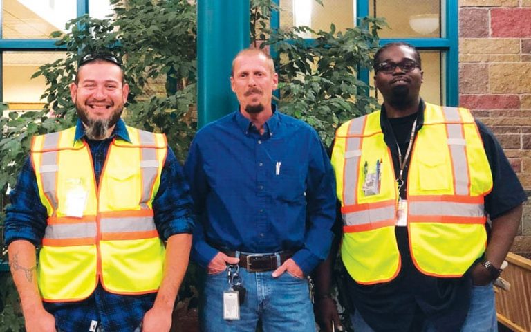 A photo of three men standing side by side