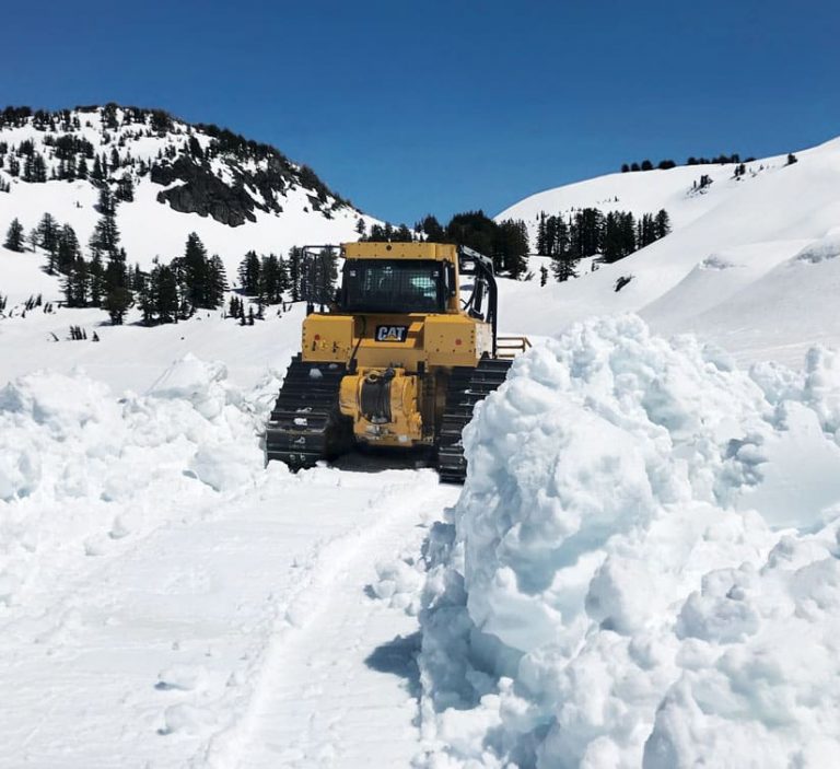 A photo of a bulldozer plowing a road