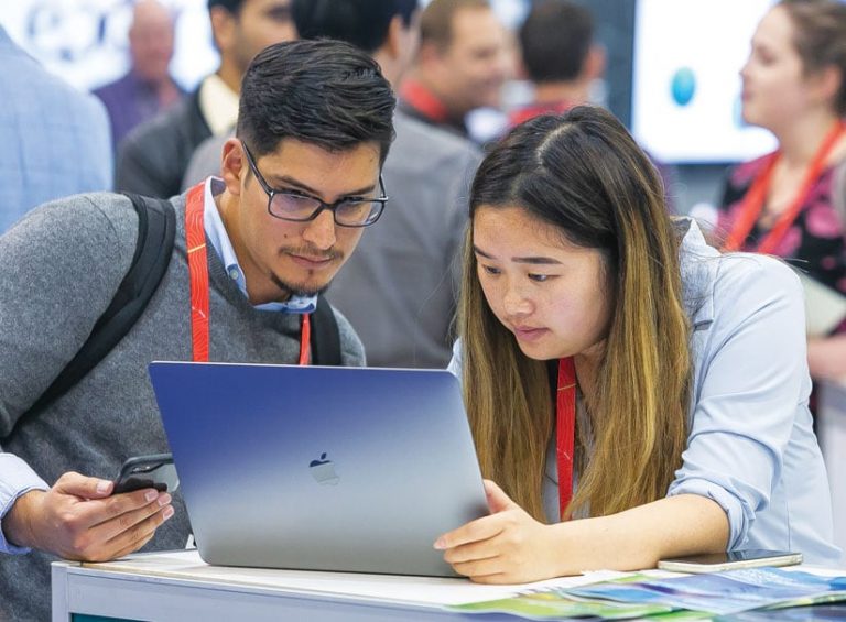 A photo of two people looking at a laptop