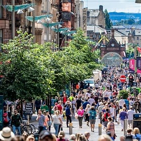 Crowds stroll a pedestrian mall with brick and mortar stores