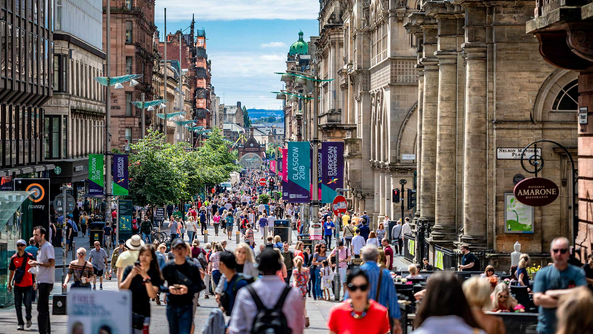 Shoppers on a pedestrian mall with brick and mortar stores