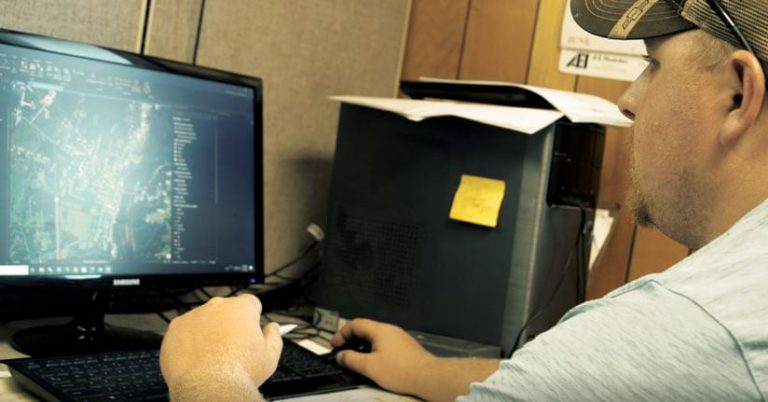 Man in a baseball cap working on a desktop computer Man in a baseball cap working on a desktop computer