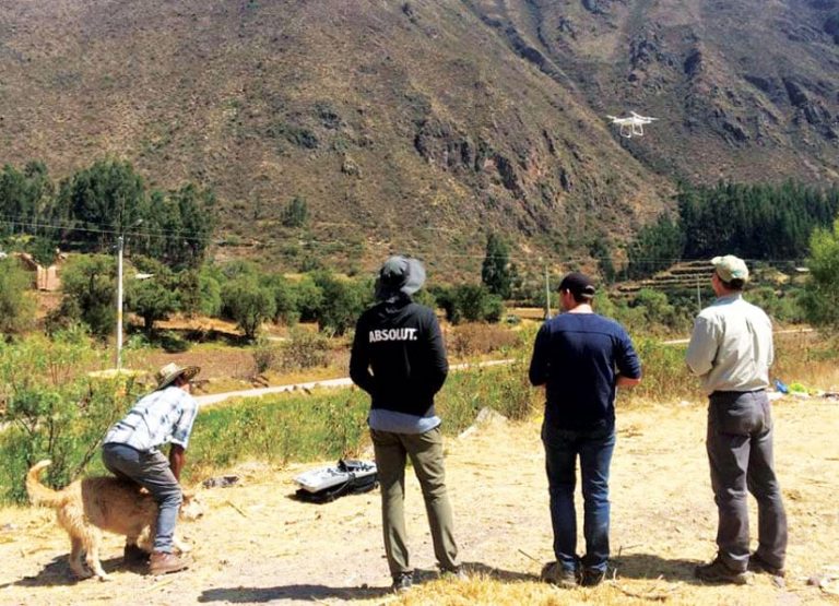 Four Andean Alliance for Sustainable Development staff members and university students standing near a mountain collecting aerial imagery