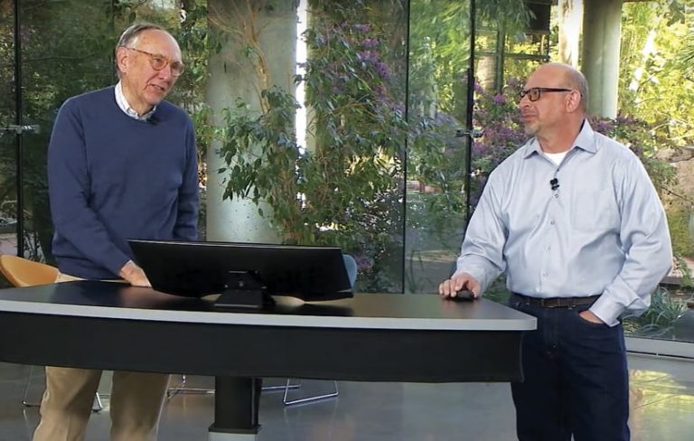 Jack Dangermond and Jim McKinney standing at a desk with a computer monitor on it