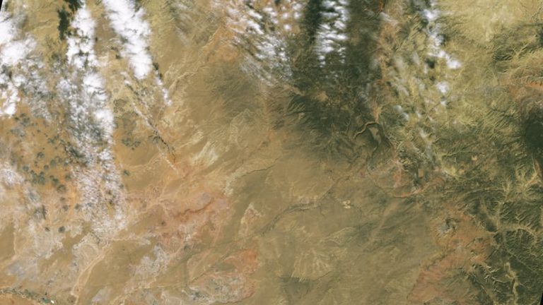 Imagery of brown land dotted with some soft clouds
