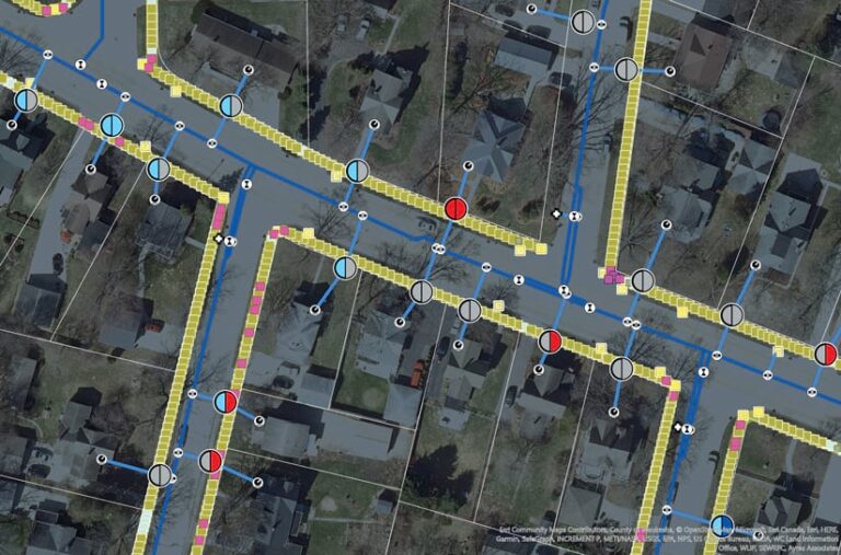 An imagery-based map of a residential area with sidewalk and utility assets overlaid