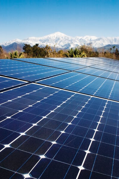 Rooftop solar panels with a snow-capped mountain in the background