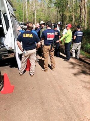 Rescue workers gathered around a van, getting briefed about the search operation