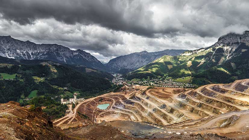 Tiers of brown land backed by mountains, representing nickel mining