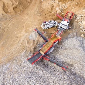 Trucks and a conveyor machine at a gravel operation
