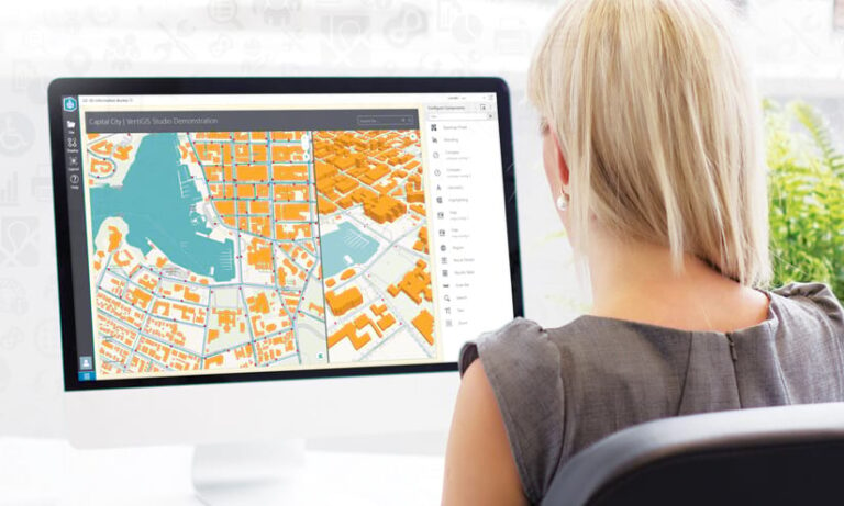 A woman sitting in front of a computer with a map on it