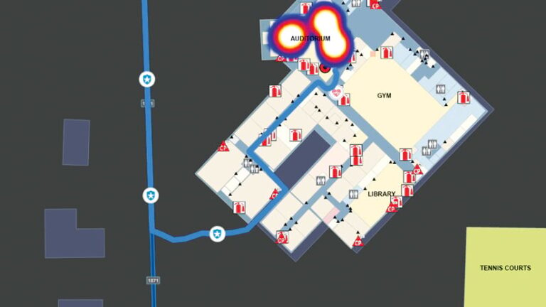 A map of the interior of a building with fire extinguishers labeled and a glowing blue and red lines in the auditorium