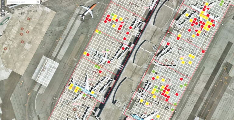 A overhead image of one of the airport’s terminals, showing the areas where airplanes are parked in a grid, with some of the squares colored green, yellow, and red A overhead image of one of the airport’s terminals, showing the areas where airplanes are parked in a grid, with some of the squares colored green, yellow, and red
