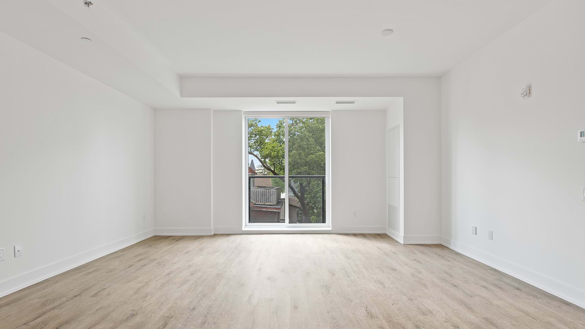 an empty apartment with a window on a backyard