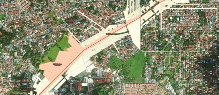 Aerial imagery of a residential area with pink and white parcels outlined near a red line