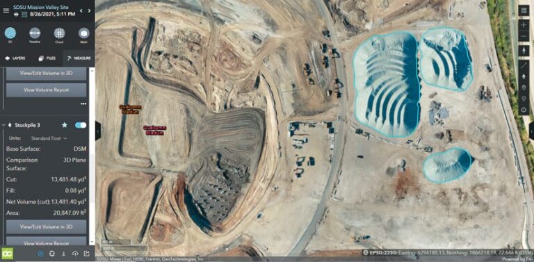 Within the Site Scan interface, an aerial view of the early stages construction site that shows three large holes in the ground highlighted in blue Within the Site Scan interface, an aerial view of the early stages construction site that shows three large holes in the ground highlighted in blue