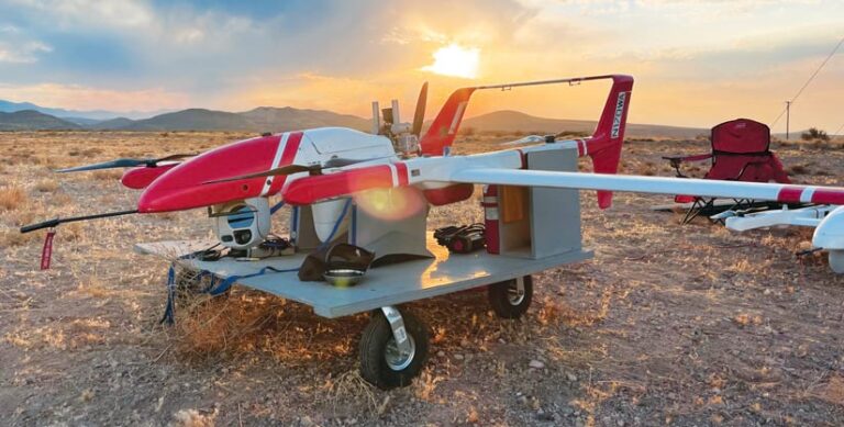 A red and white drone sitting on a carrier in the desert A red and white drone sitting on a carrier in the desert