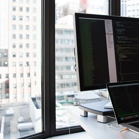 A computer monitor against a city backdrop