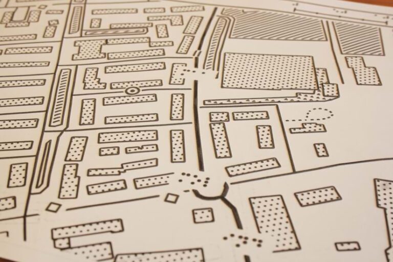 A close-up of a tactile map that shows roads and buildings in black-and-white, raised print