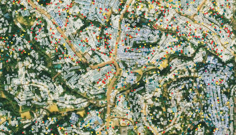 An aerial photo of a rural area with differently shaped rectangles and colorful dots showing where buildings are located